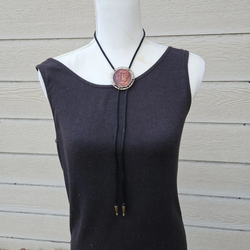 gold tone and brown leather abstract face bolo tie on black cord